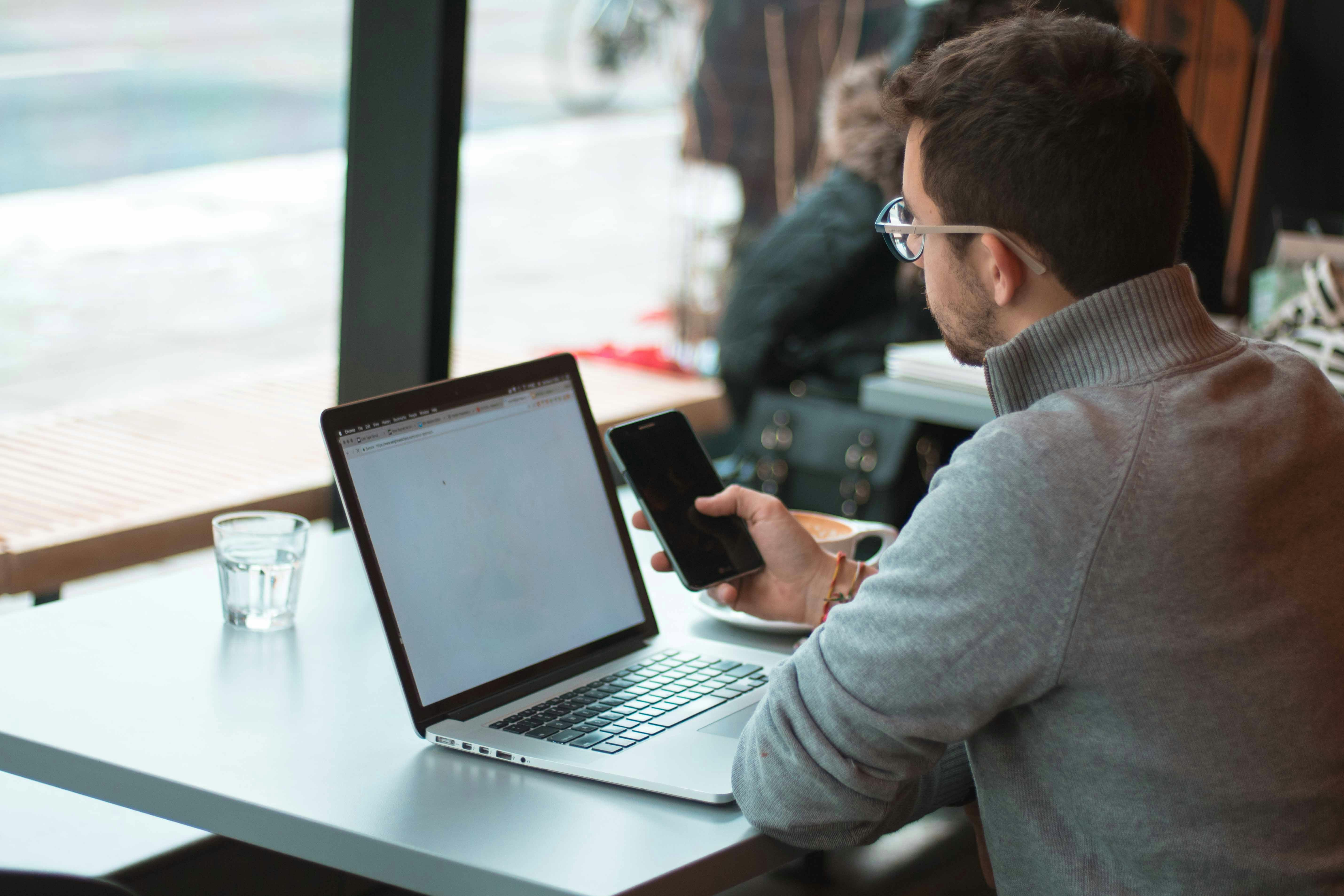 Business owner managing their Google Business Profile listing on a laptop and phone
