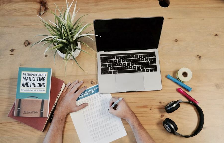 Small business owner planning website and SEO strategy at a desk with marketing materials