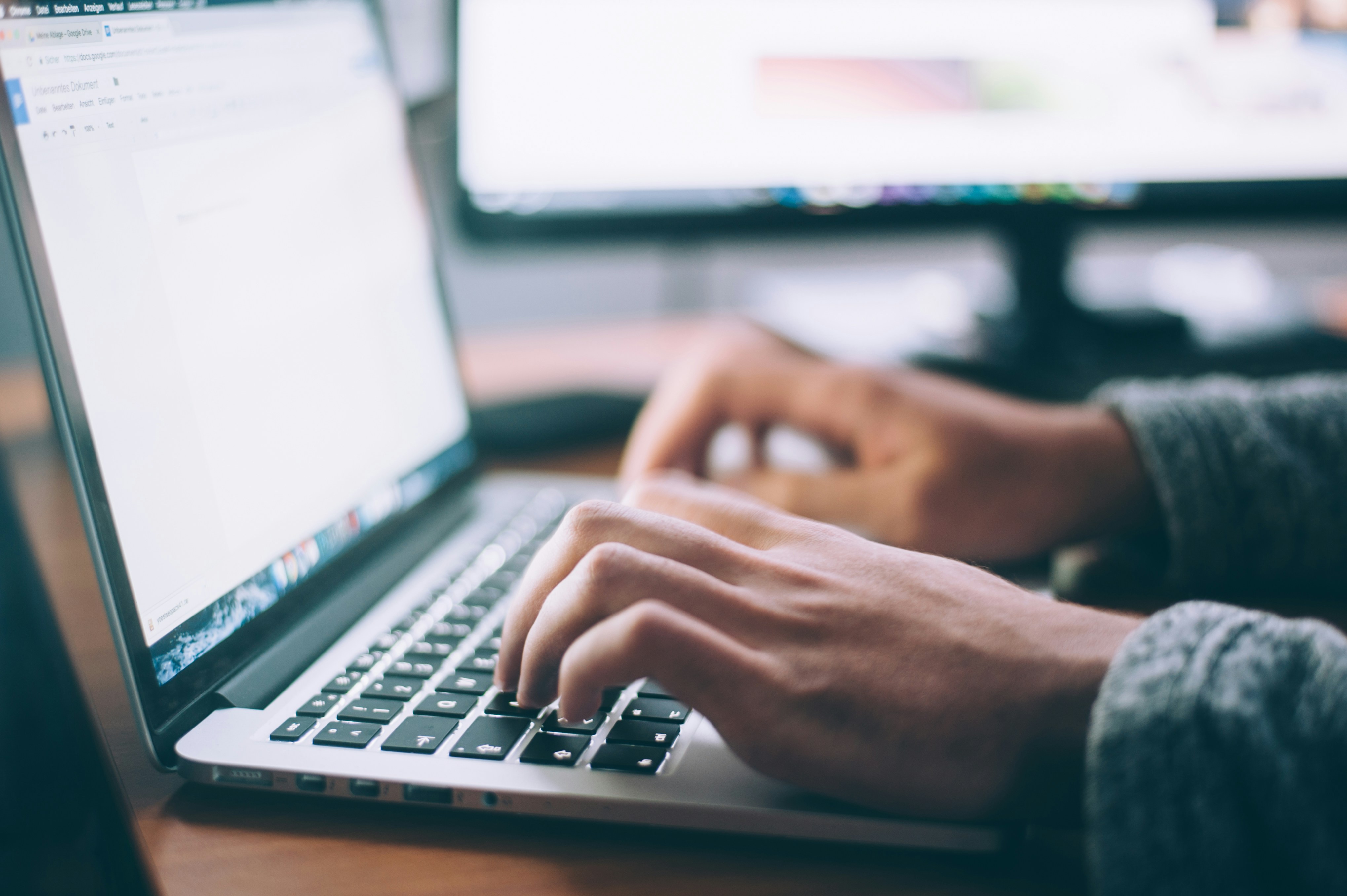 Close-up of hands typing on a laptop keyboard while checking a website's search visibility